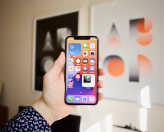 An illustration of a hand holding a smartphone displaying multiple game icons.